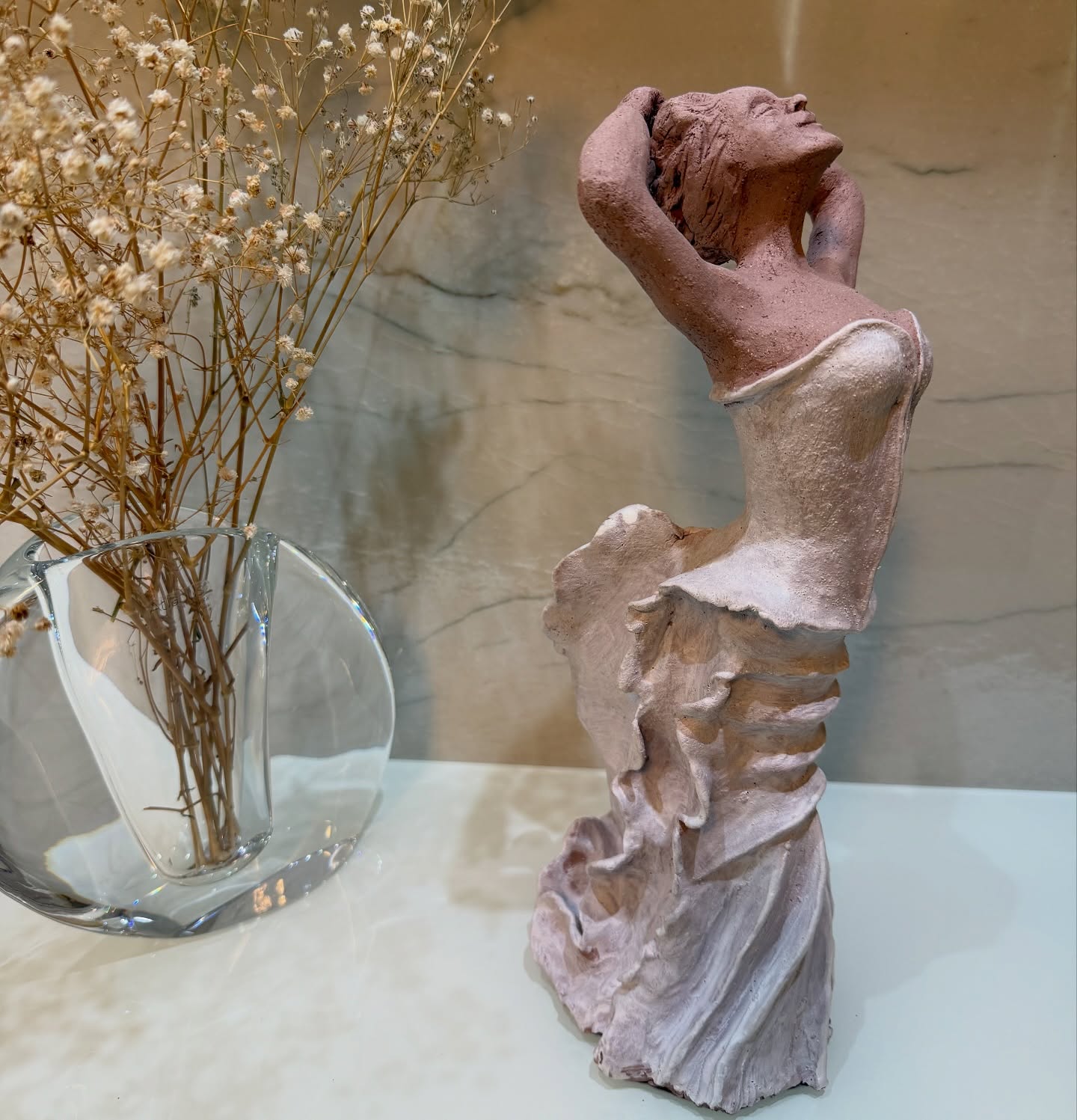 Detalhe de uma figura feminina em dança, com acabamento rosa suave